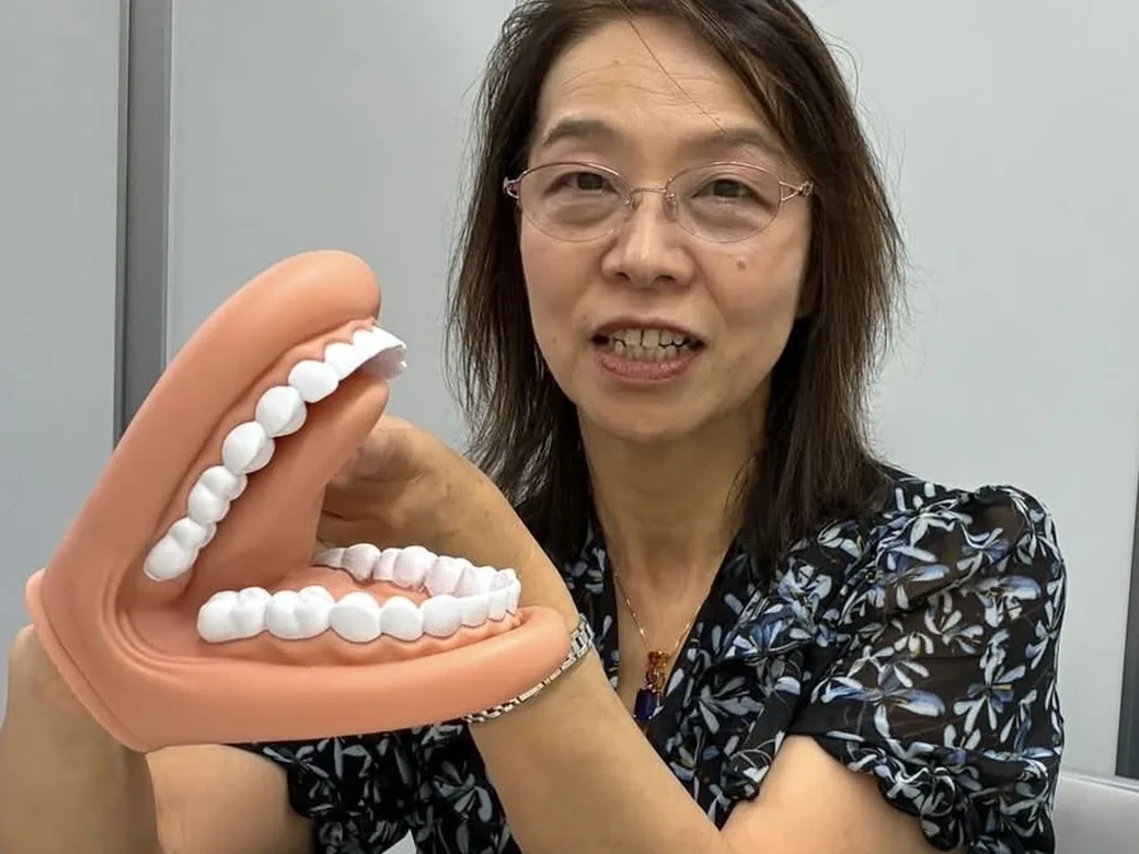 歯の模型を使って舌の動きを説明する院長
